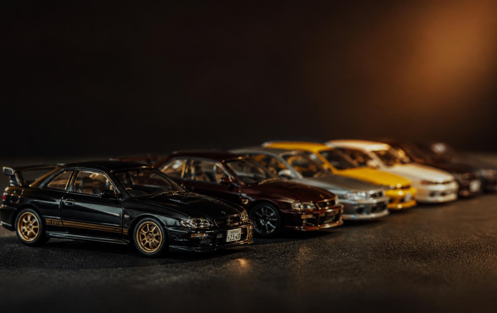 Miniaturas colecionáveis 1:64 alinhadas sobre superfície escura